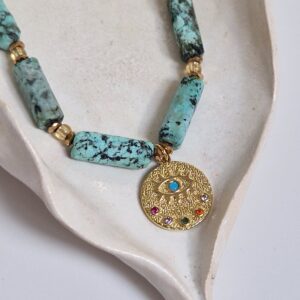 Naszyjnik z nieregularnych turkusów z zawieszką.